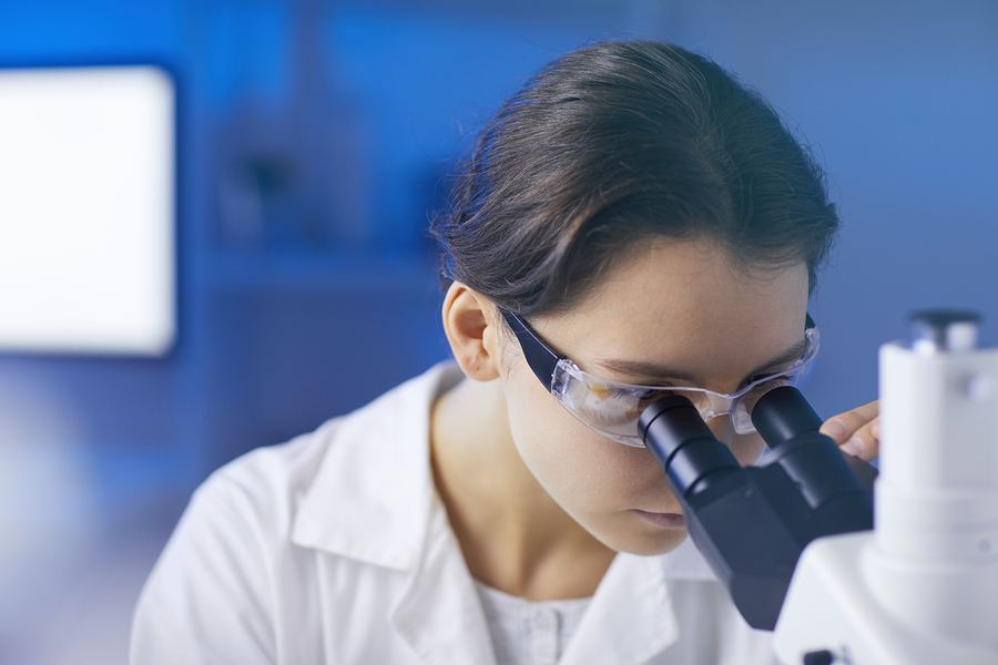 Closeup Portrait Of Young Female Scientist Looking In Microscope
