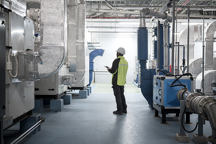 Asian Engineer Performing Pipe System Inspection in Modern Industrial Facility