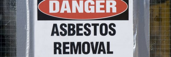 Danger Asbestos Removal Sign posted on school window.