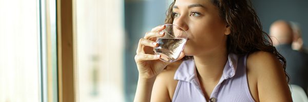Distracted Woman Drinking Water In A Restaurant Looking Away Thr