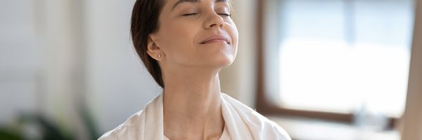 Content Woman Sitting On Sofa With Closed Eyes Breathing Air